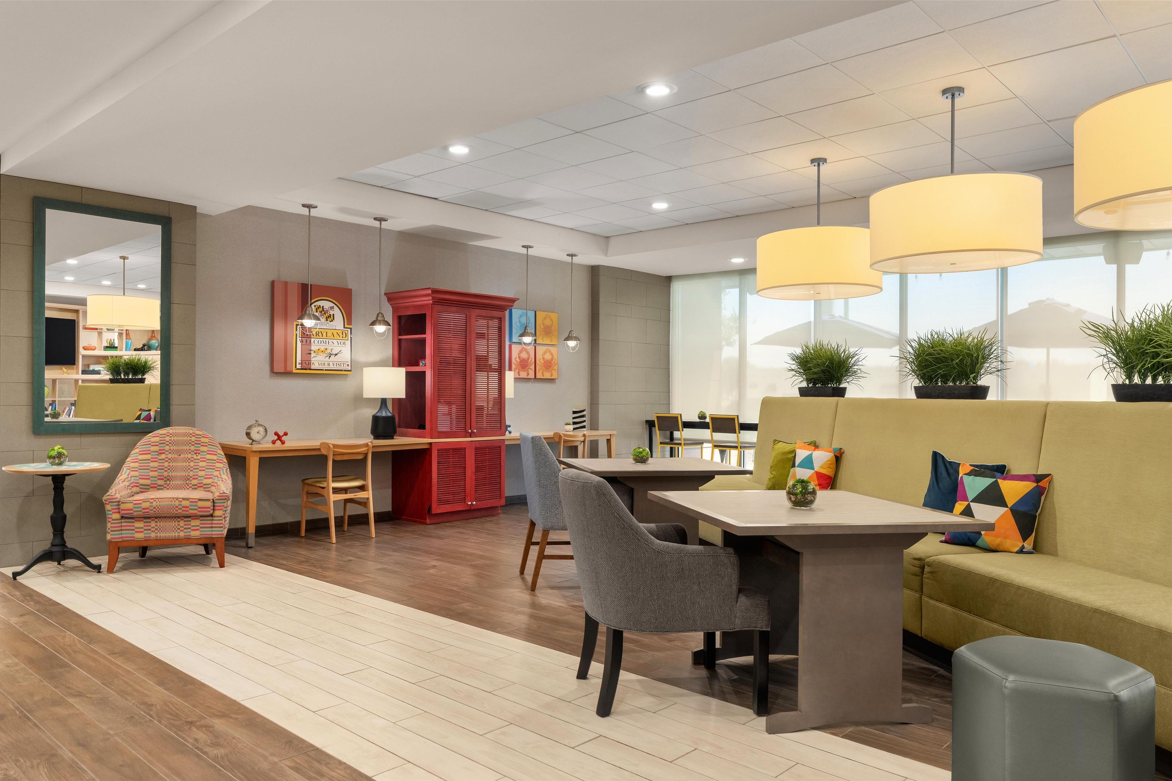A modern interior with a dining area, seating, and a kitchen in the background.