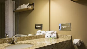 A bathroom with a granite countertop, a sink, a mirror, and a towel rack.