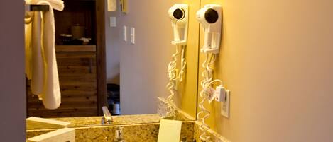 A bathroom with a sink, mirror, towel rack, and hairdryer.
