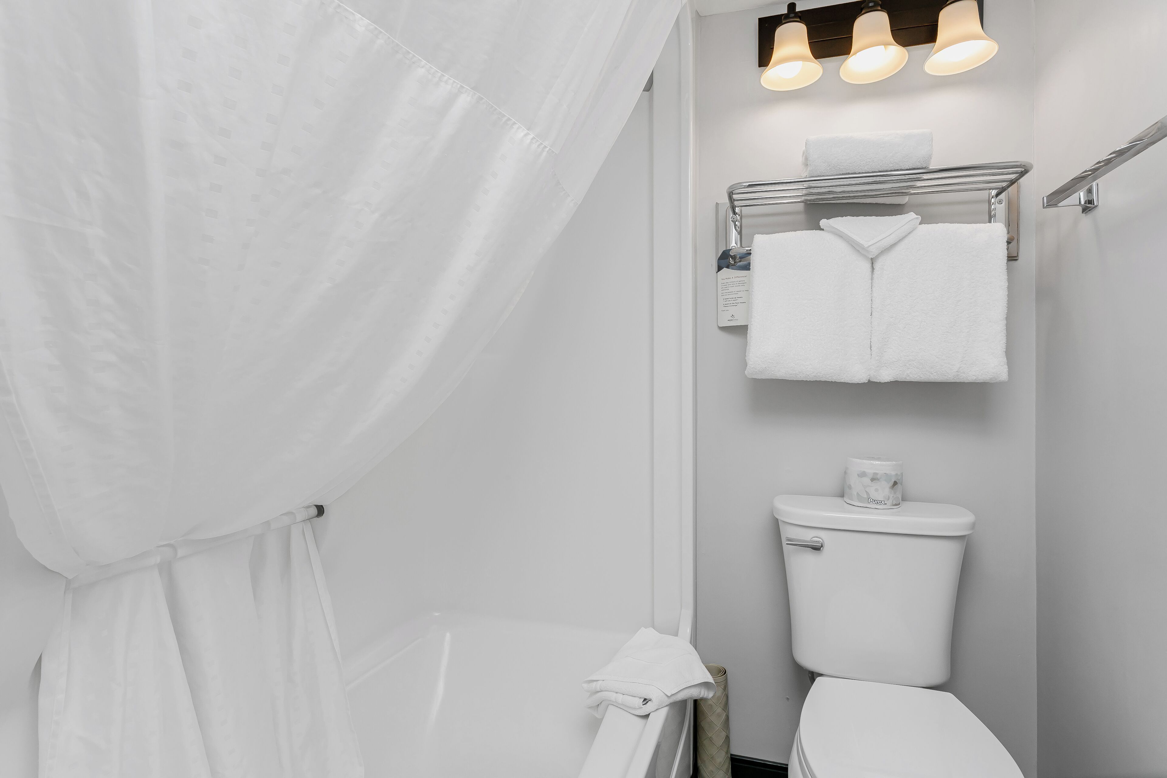 Ein Badezimmer mit Toilette, Handtuchhalter und Duschvorhang.