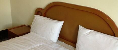 Una cama bien hecha con sábanas blancas en una habitación de hotel.