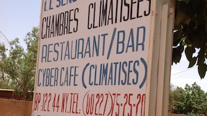 A sign for a hotel/bar with contact information including a phone number, fax number, and email address. - Nikki Hotel (Niamey)
