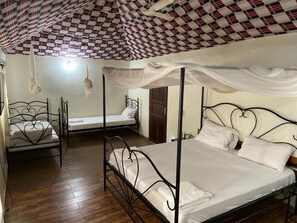 A room with a checkered ceiling, a bed with a canopy, and a window with curtains.