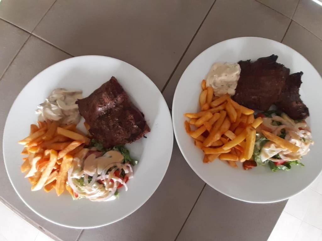 Dos platos de comida con bistec y papas fritas.