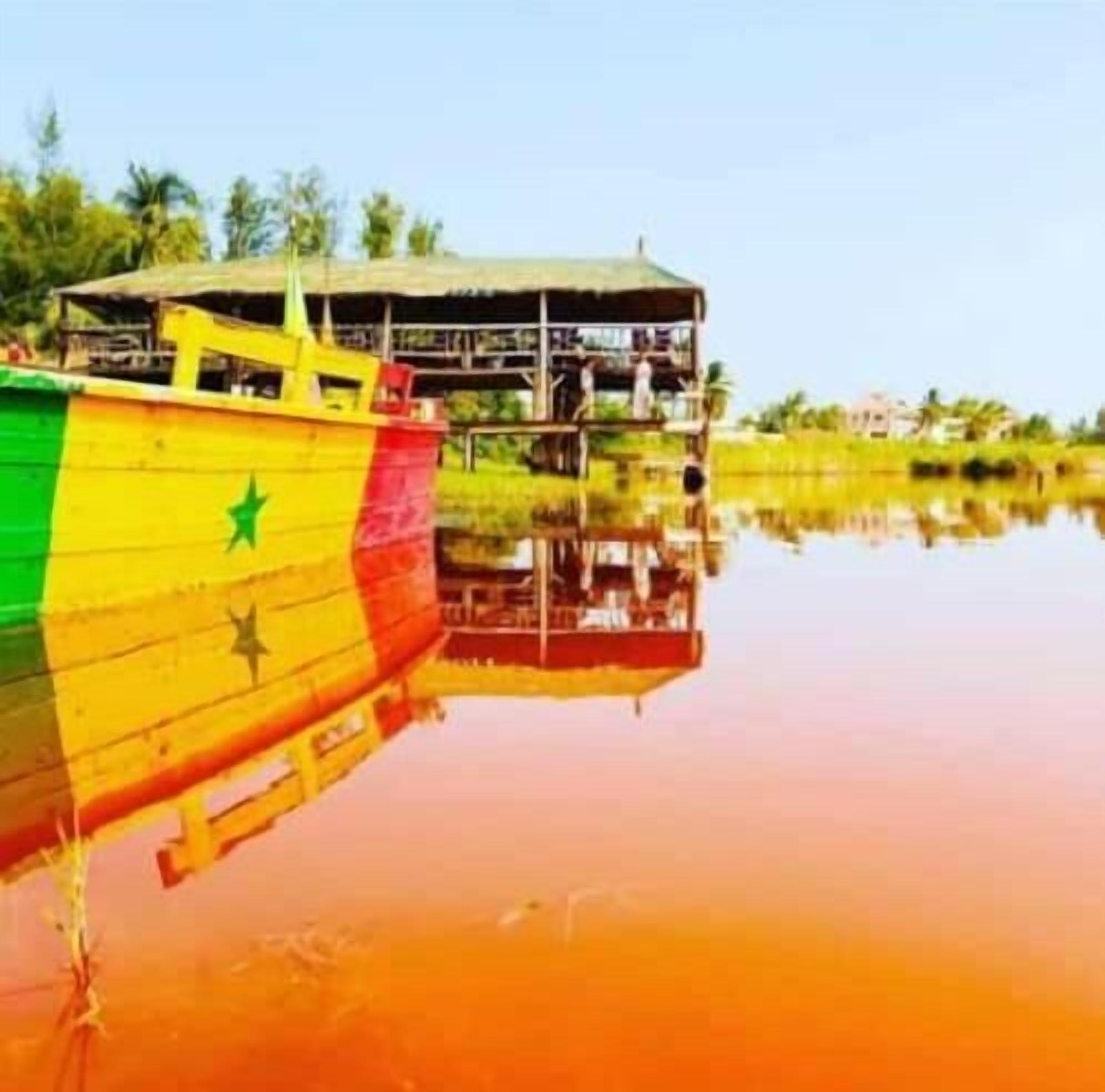 Un bote con una estrella verde y franjas amarillas amarrado cerca de una estructura con techo.