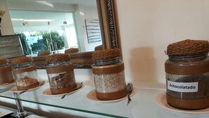 Een buffetgedeelte met diverse gerechten, waaronder potjes met chocoladepasta, plakjes watermeloen en ander fruit.