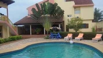 Una piscina al aire libre, tumbonas