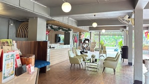 L’intérieur d’un restaurant, avec un comptoir, un espace pour s’asseoir et une vue sur l’extérieur.