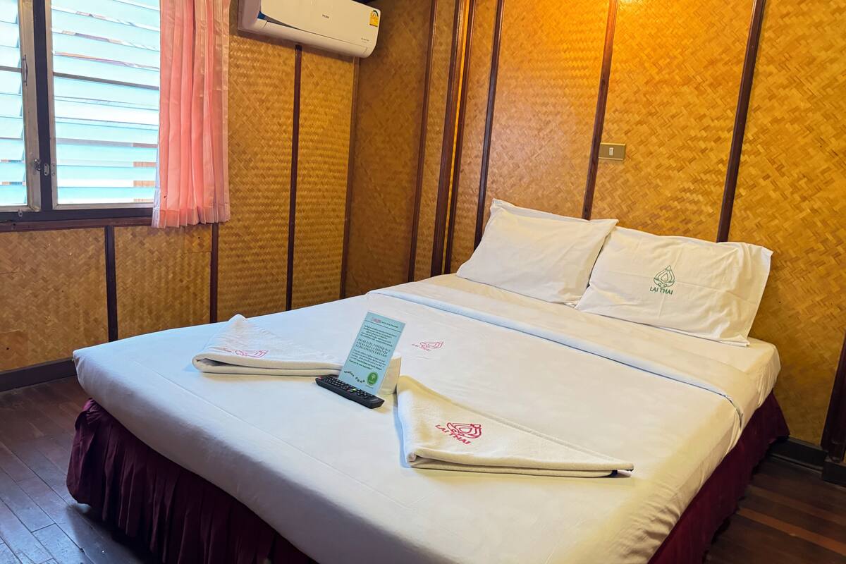 Een hotelkamer met een bed, een afstandsbediening en een menukaart op het bed.