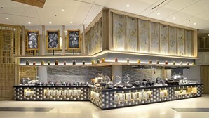 Een buffetopstelling met meerdere bedieningspunten, diverse etagères en een decoratieve wand met een krijtbordmenu.