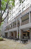 Un edificio de varios pisos con áreas de estar al aire libre y un patio.