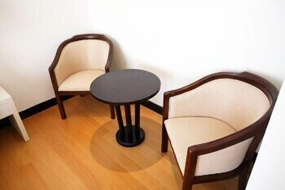 A room with two wooden chairs and a small round table.