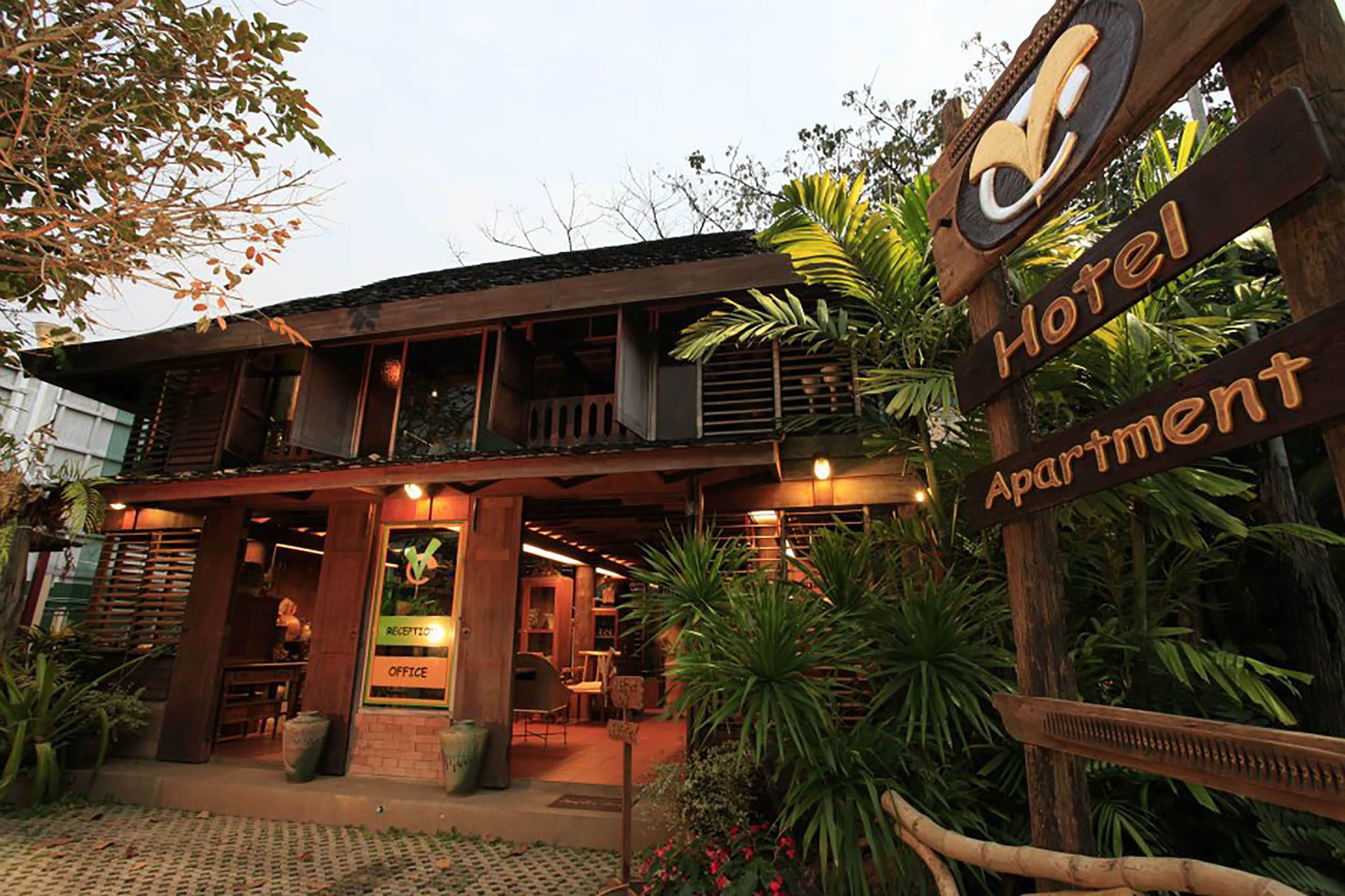 A hotel with a wooden facade, a reception desk, and a sign indicating it's an apartment hotel.