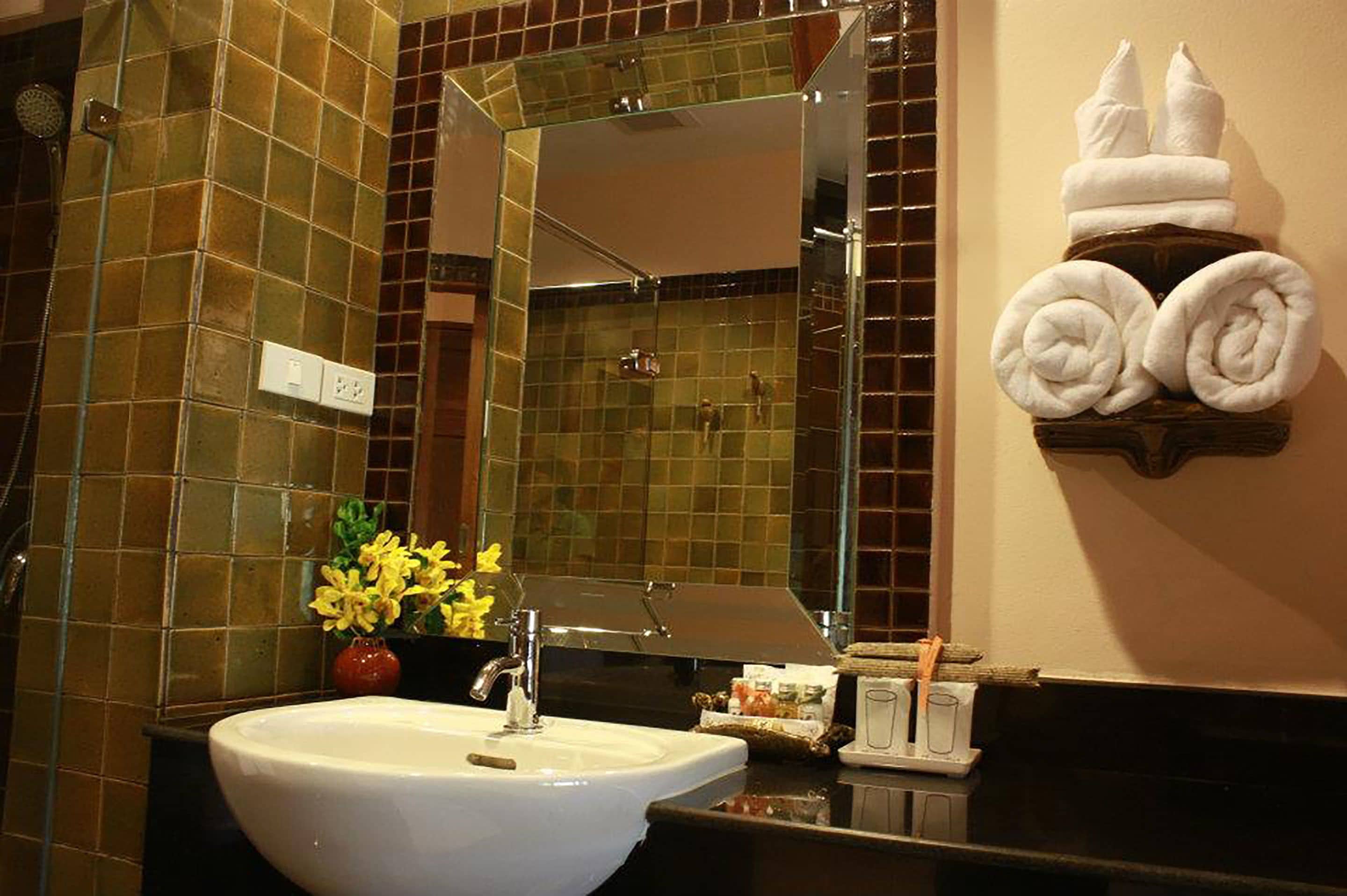 Un baño con lavamanos blanco, cabina de ducha de vidrio y espejo.