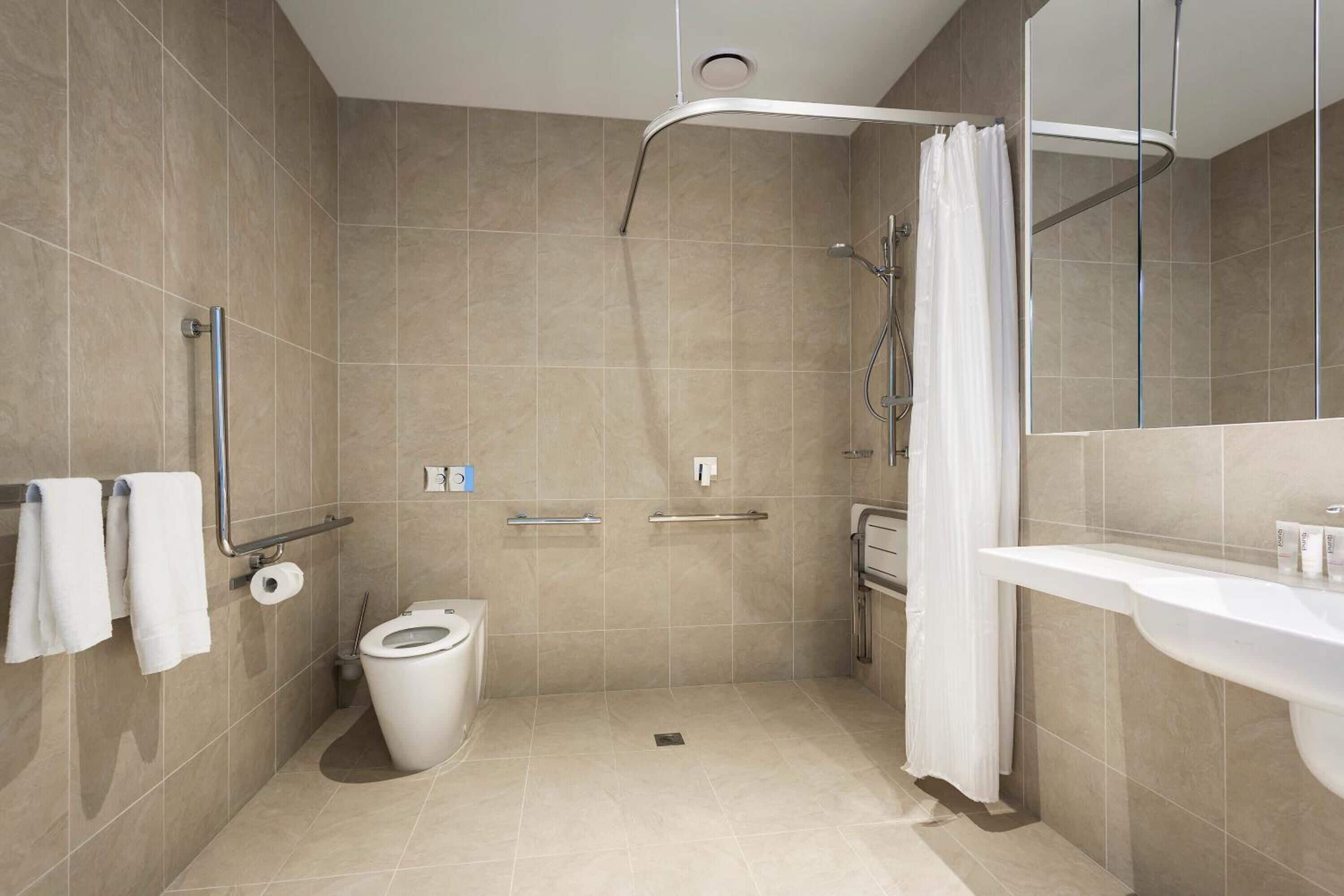 A modern bathroom with a shower, toilet, and sink.