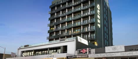 A multi-story building with a cafe named "Quest Cafe" on the ground floor.