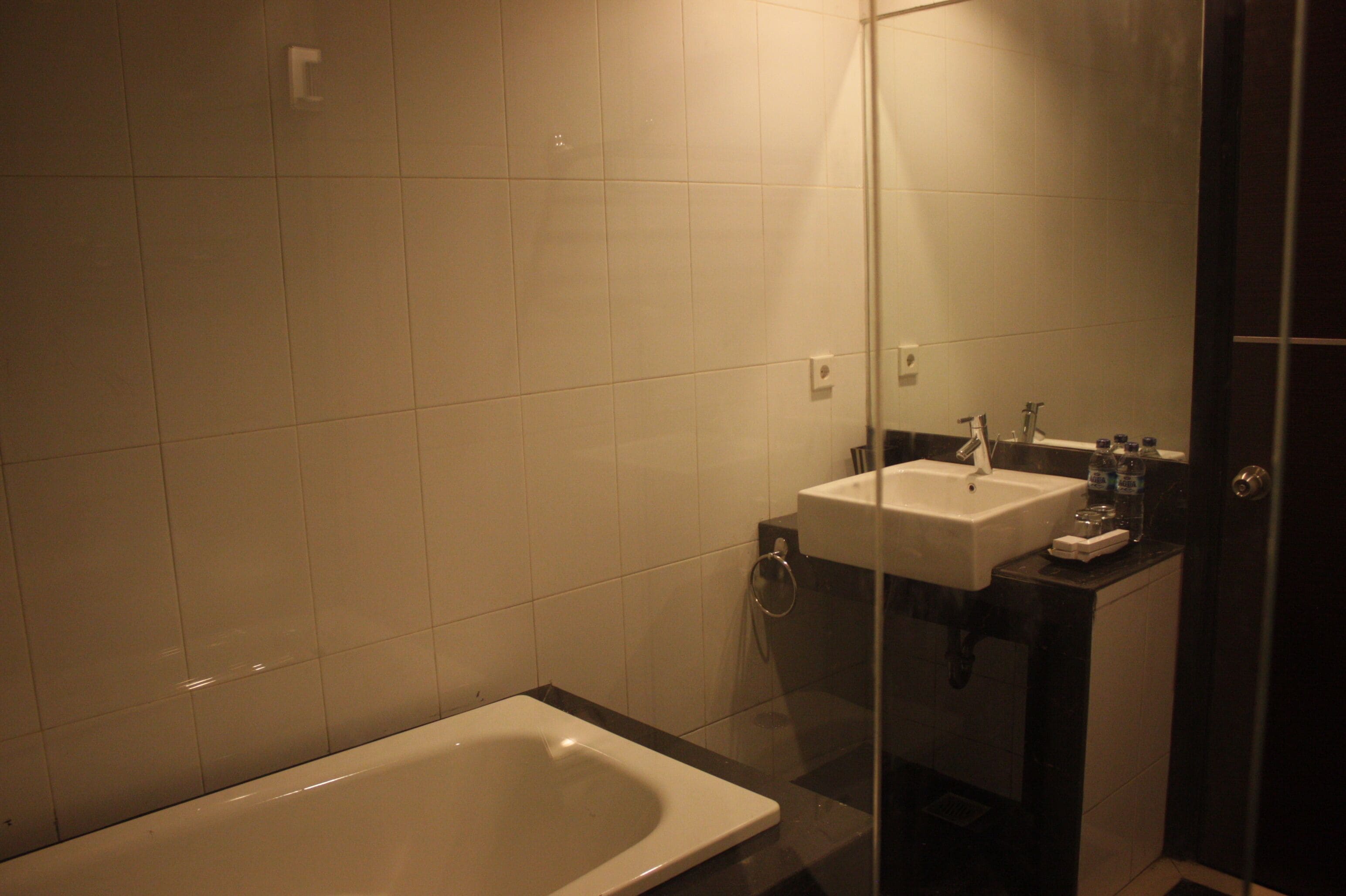 Un baño con bañera, lavamanos y cabina de ducha de vidrio.