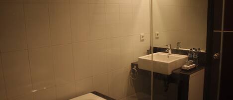 Un baño con bañera, lavamanos y cabina de ducha de vidrio.