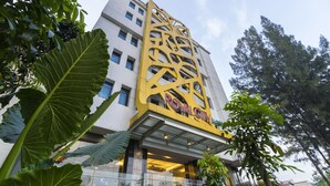 Un hôtel doté d’une façade moderne, de grandes fenêtres et d’une structure décorative jaune bien visible.