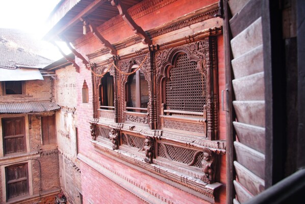 A traditional building with intricate wooden carvings and a red brick facade.