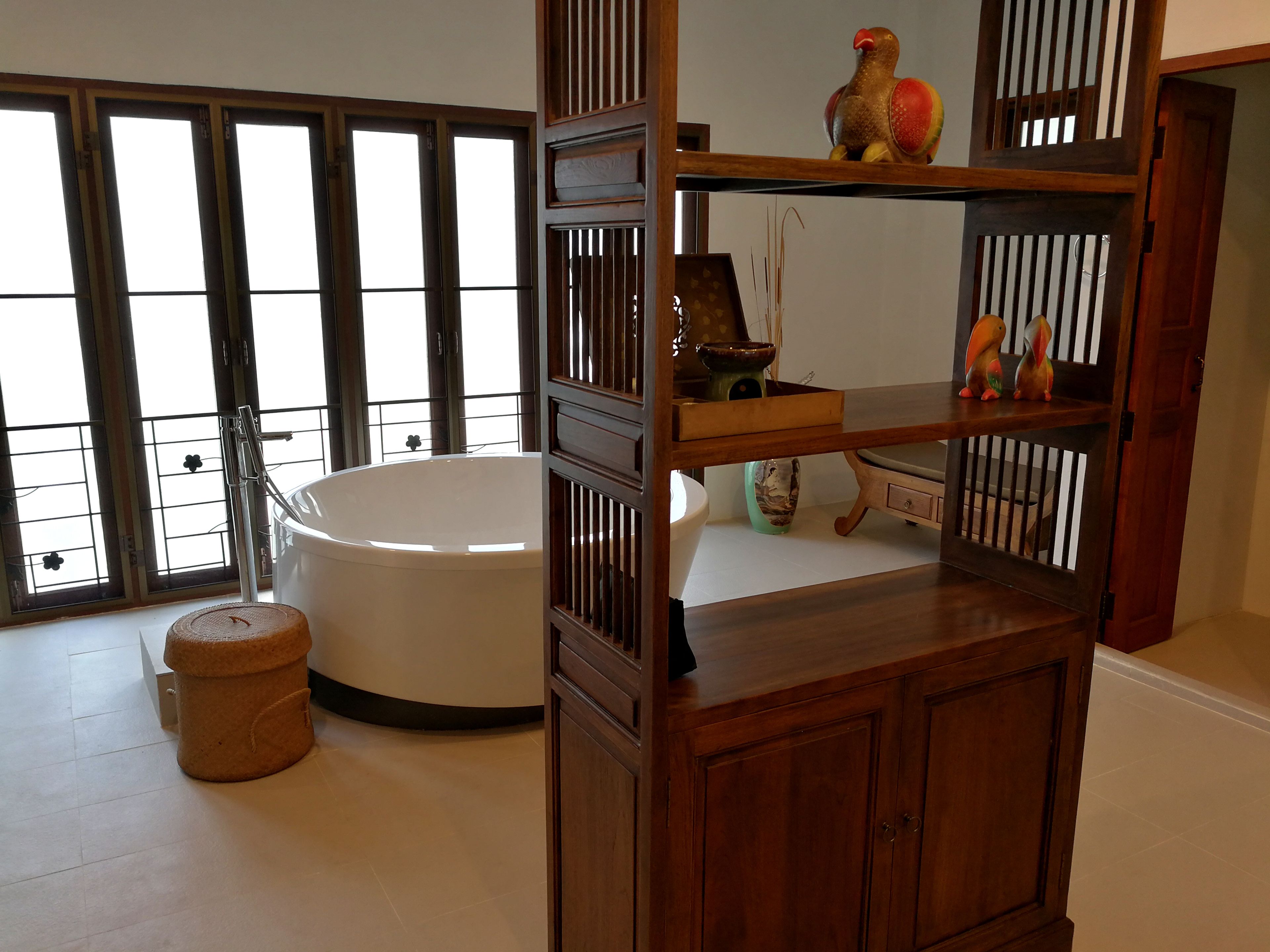Ein Badezimmer mit einer Badewanne, Holzregalen und einem Fenster mit Blick.