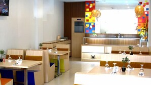 A modern hotel lobby with a central reception desk, seating areas, and a colorful wall decoration. - Paramita Hotel (Pekanbaru)