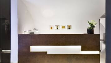 A reception desk with a minimalist design, featuring a dark brown counter and a white illuminated panel.