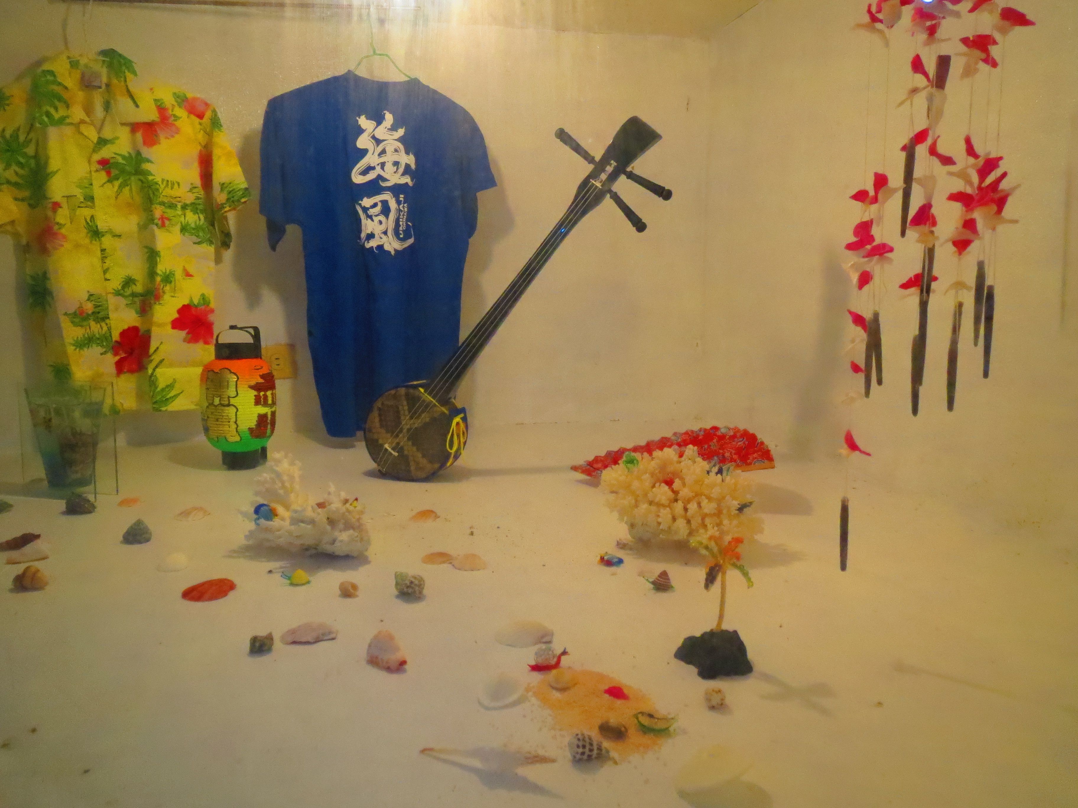 A room with a blue shirt, a musical instrument, and decorative items.