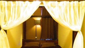 A room with a bed, two pillows, and a window with curtains. - Stella Resort - Hostel (Naha)