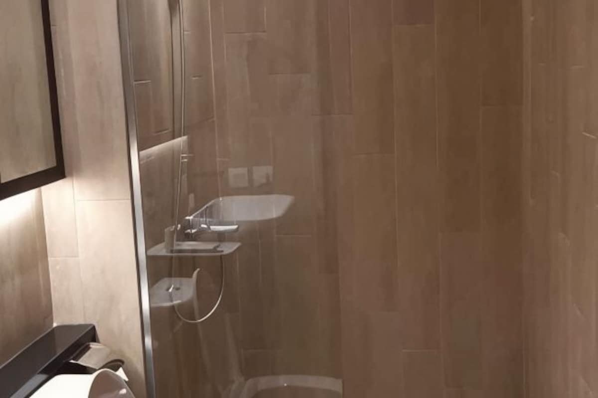 A bathroom with a glass shower enclosure, a sink, and a toilet.