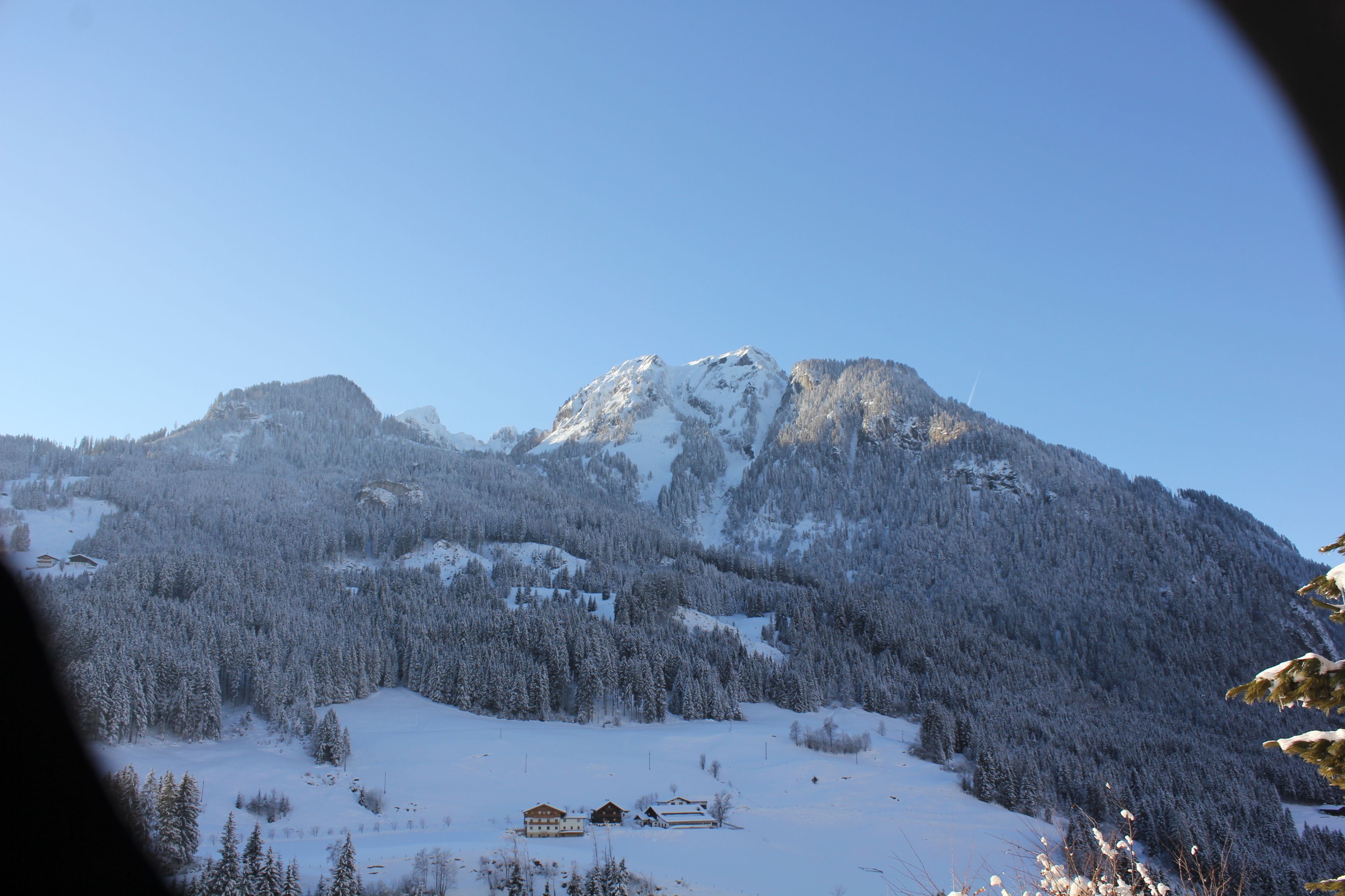 Ein mit Schnee bedeckter Berg, im Vordergrund ein kleines Gebäude.