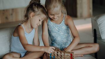Dos niños sentados en un sofá jugando un juego de mesa de madera.