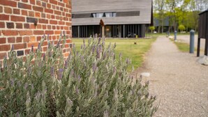 A pathway leading to a building with a brick facade and a modern design. - Nørre Vosborg Herregård (Vemb)