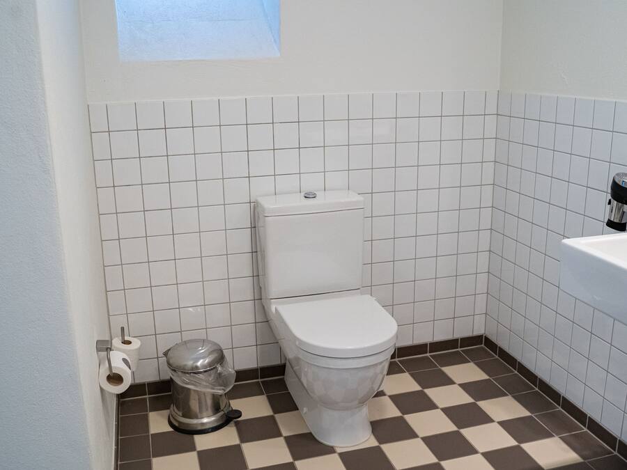 Un baño pequeño con un inodoro, un bote de basura y una bañera.