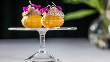 Deux petits gâteaux décorés, présentés sur un présentoir en verre transparent, avec un arrière-plan flou.