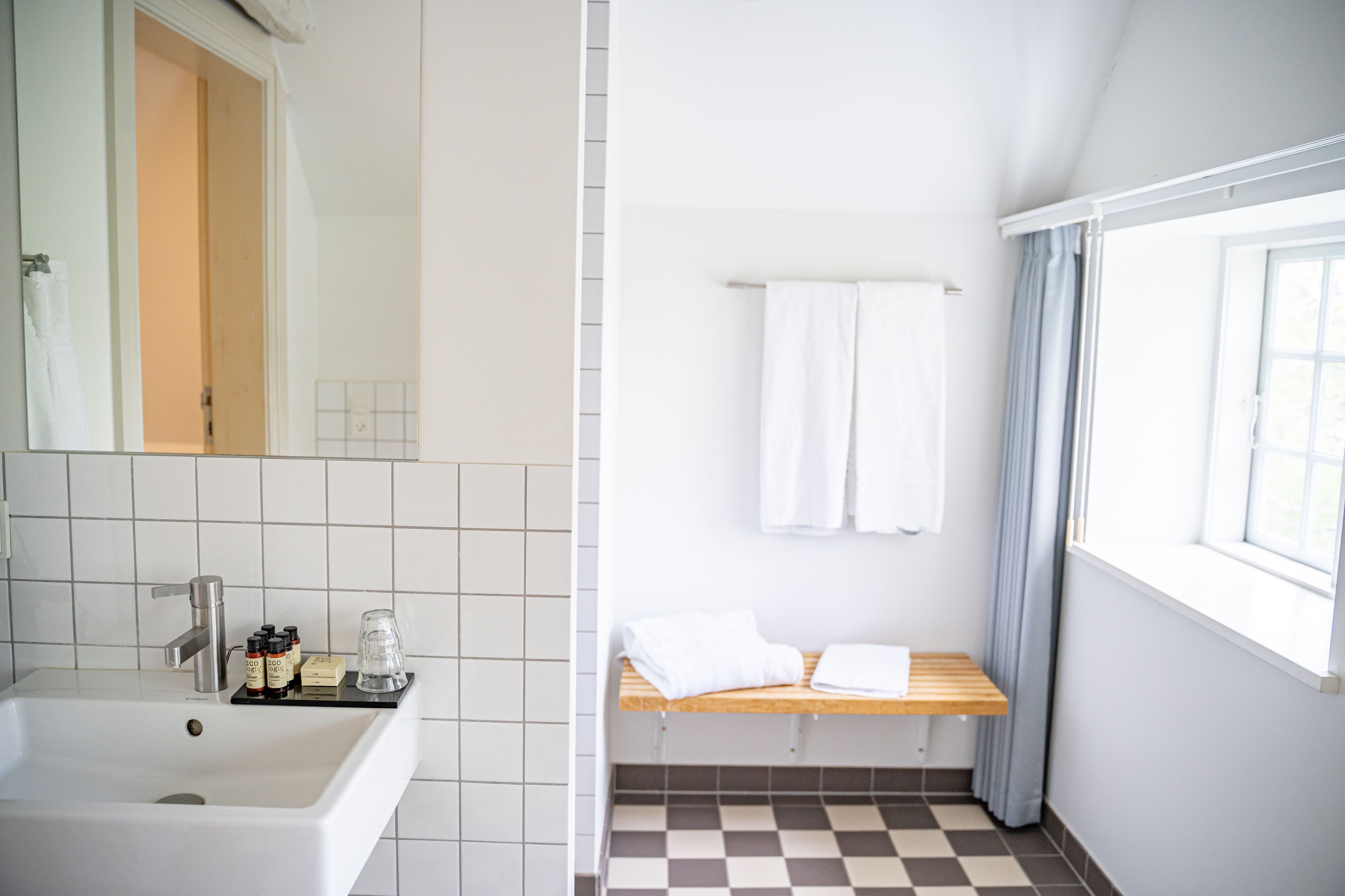 A bathroom with a sink, mirror, and towel rack.