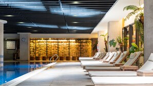 Uma área de piscina com espreguiçadeiras e uma receção.