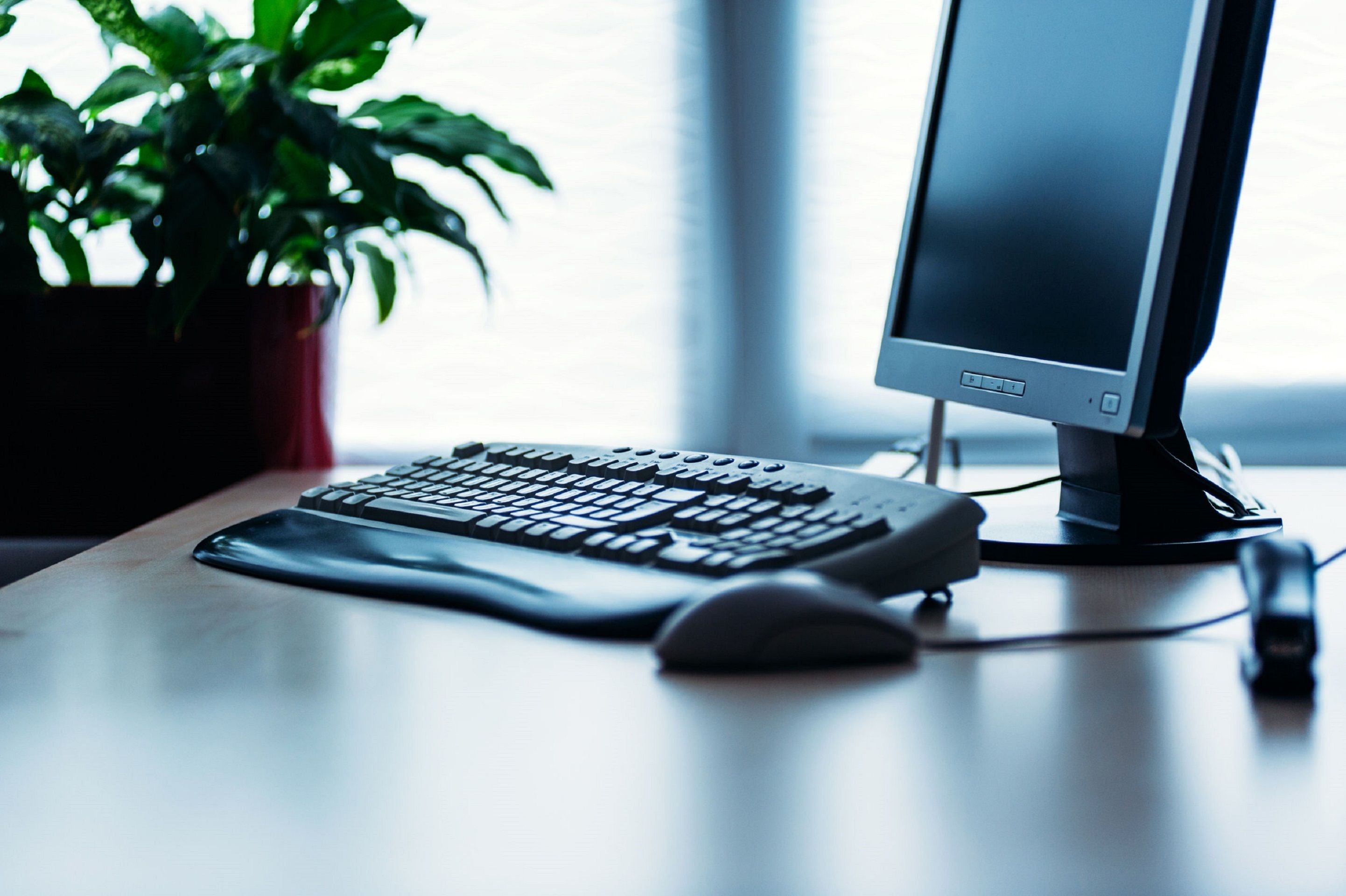 Un ordinateur de bureau installé sur un bureau, avec un clavier, une souris et un écran.