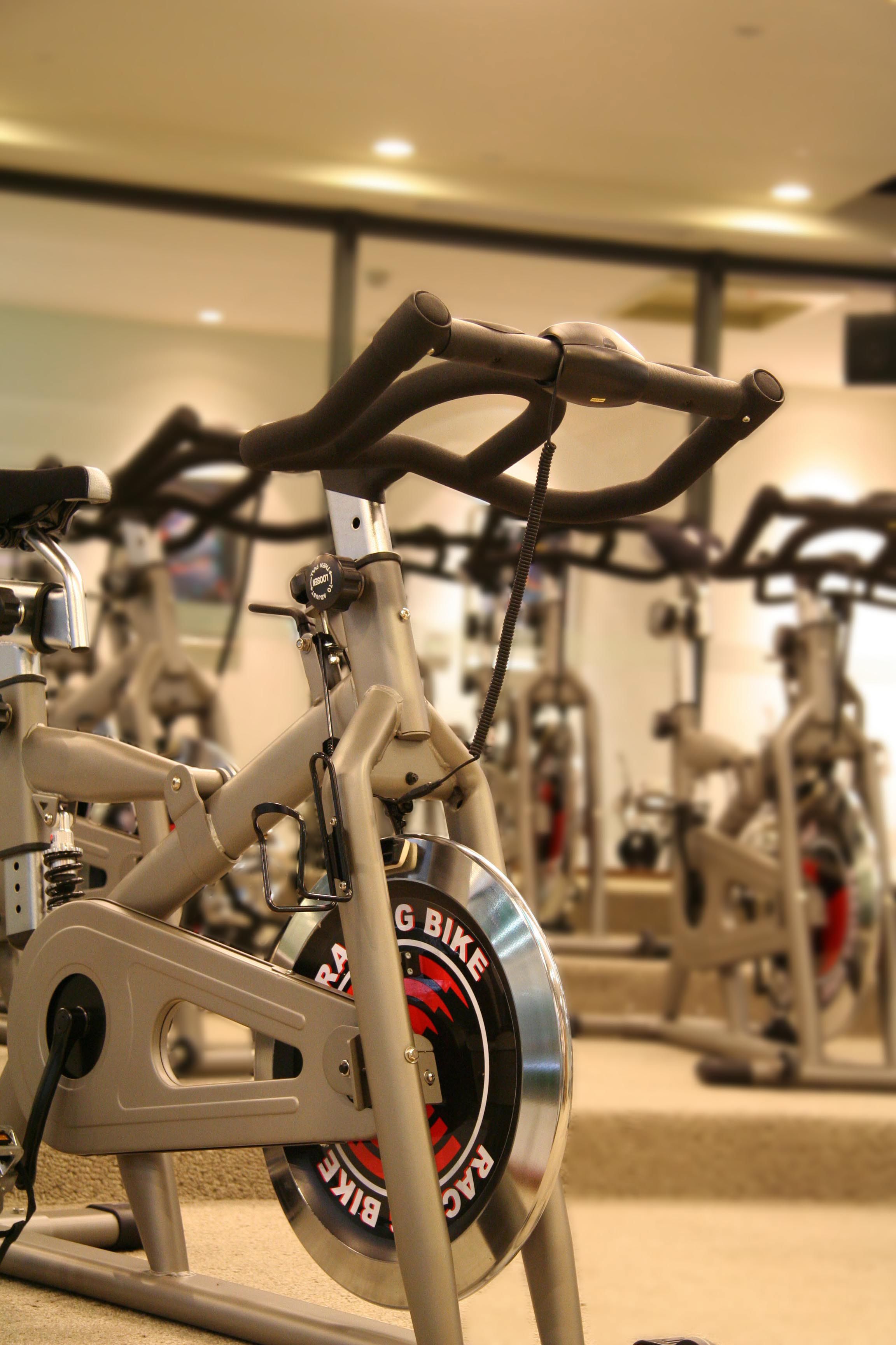 A stationary bike in a gym with a mirrored wall in the background.