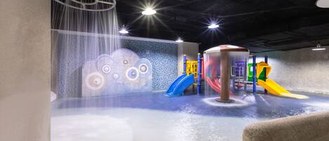An indoor play area with a water feature and slides.