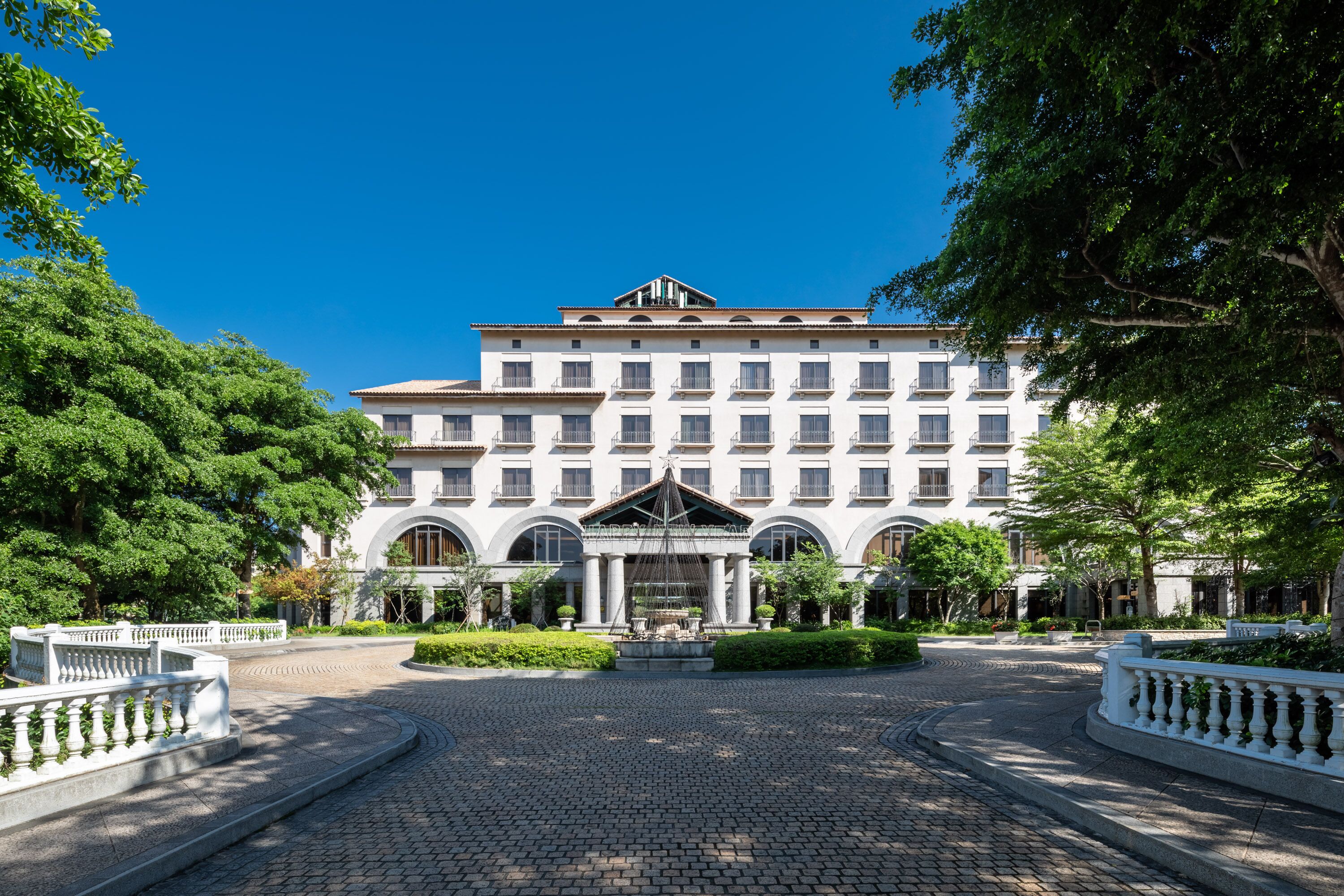 A large, multi-story hotel with a central courtyard, arched windows, and a fountain.