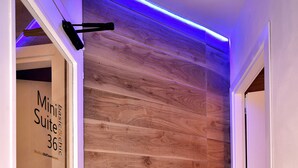 Un pasillo con paneles de madera y un cartel que indica 'Mini Suite 36'.