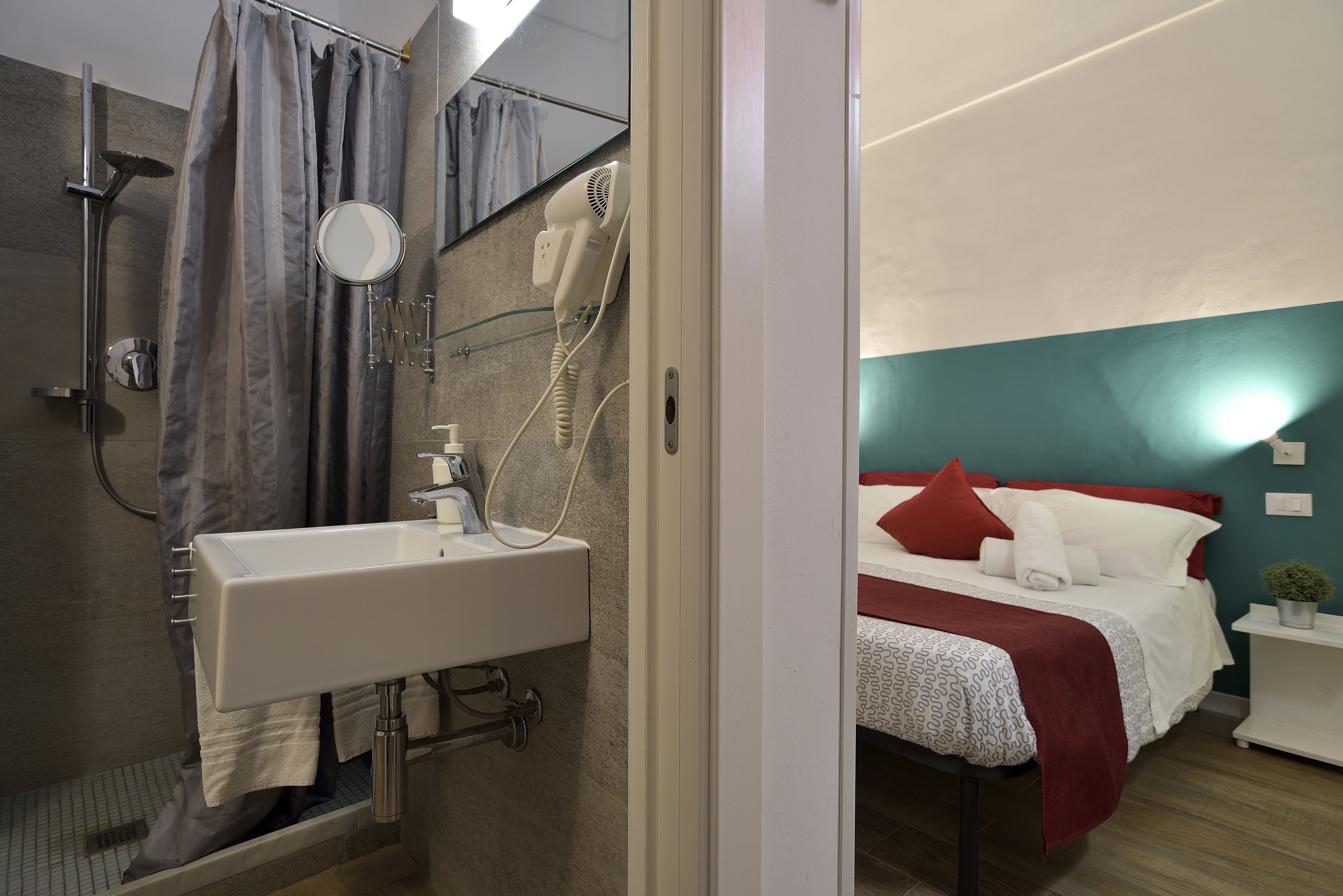 A bathroom with a shower, sink, and mirror.