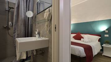 A bathroom with a shower, sink, and mirror.