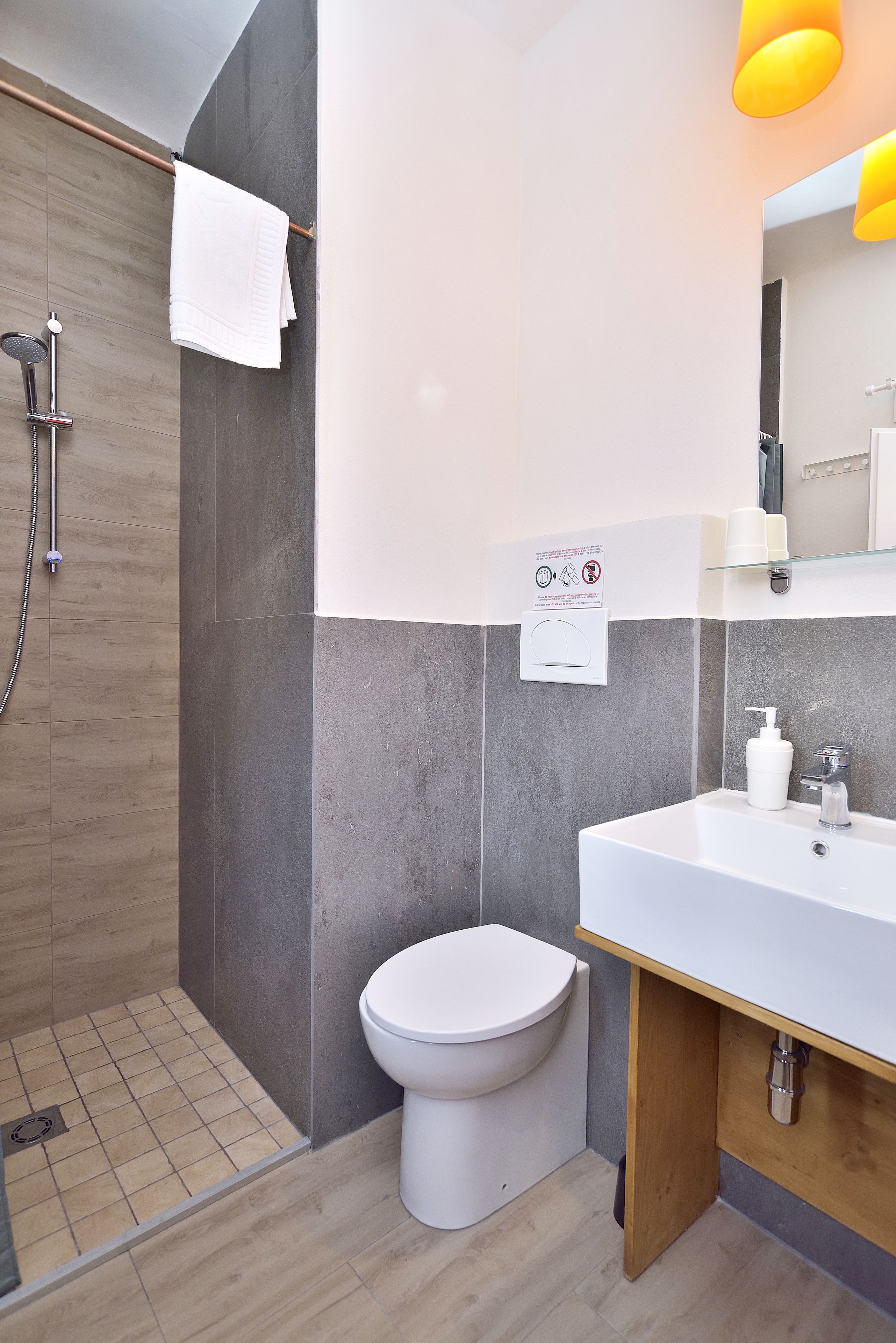A modern bathroom with a shower, toilet, and sink.