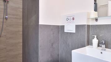 A modern bathroom with a shower, toilet, and sink.