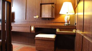A wooden room with a bench, a desk, a lamp, and a door with a keyhole.