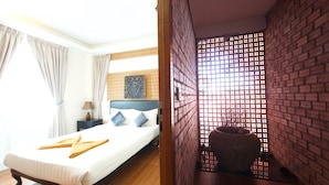 Una habitación de hotel con una cama, una mesita de noche, una lámpara y un adorno en la pared.