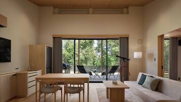 A modern interior with a dining area, sofa, and large sliding glass doors leading to an outdoor deck.