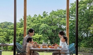 A dining table with food and drinks, surrounded by chairs, in an outdoor setting with trees in the background. - Nemu Resort Hotel Nemu (Shima)